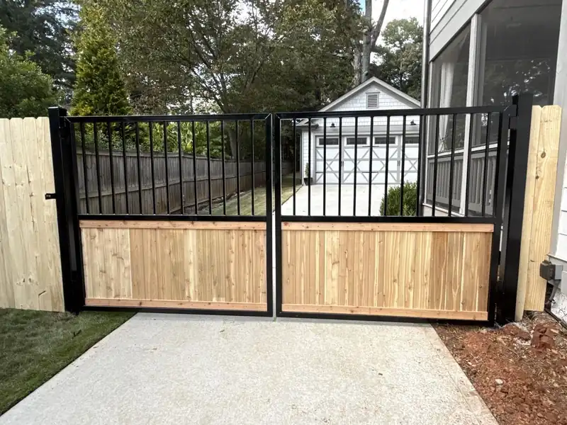 Black automated driveway gate with cedar wood panels