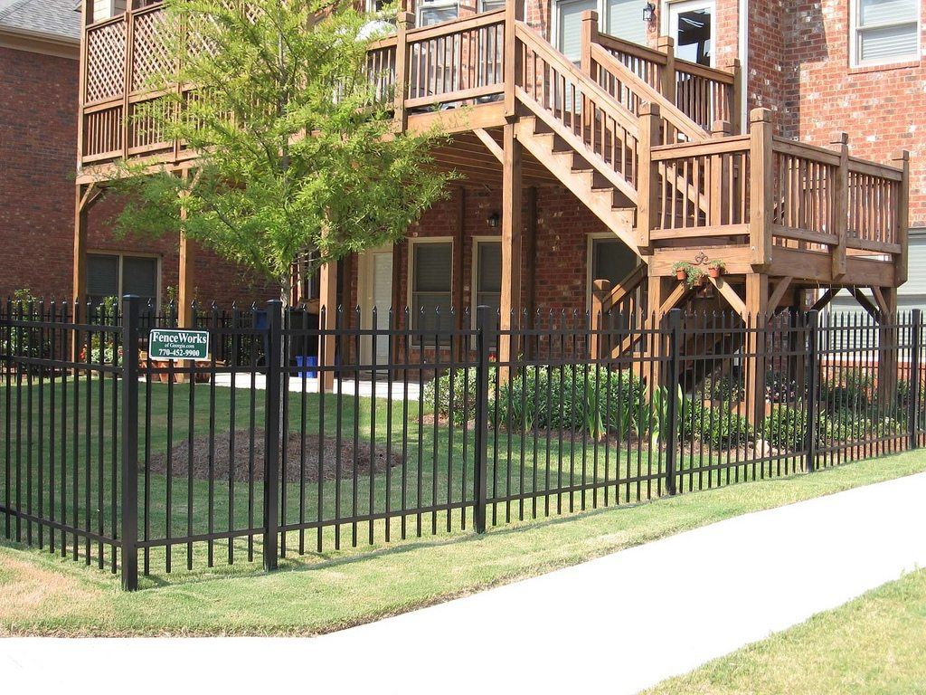 Black spear-top aluminum fence beside a brick home