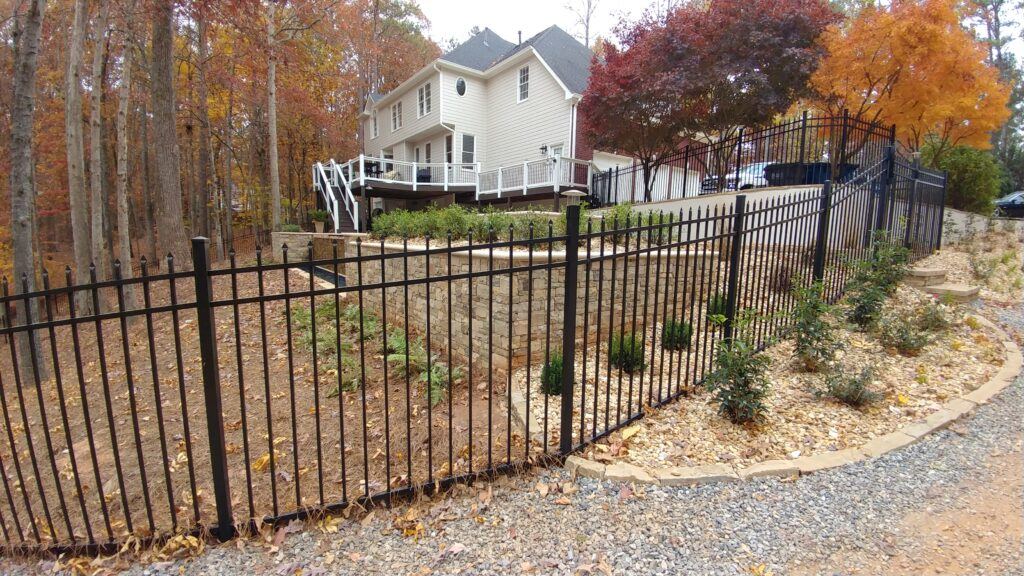 Black spear-top aluminum fence along a yard