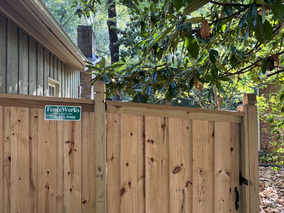 Board-on-board capped wood privacy fence with dado posts built by FenceWorks