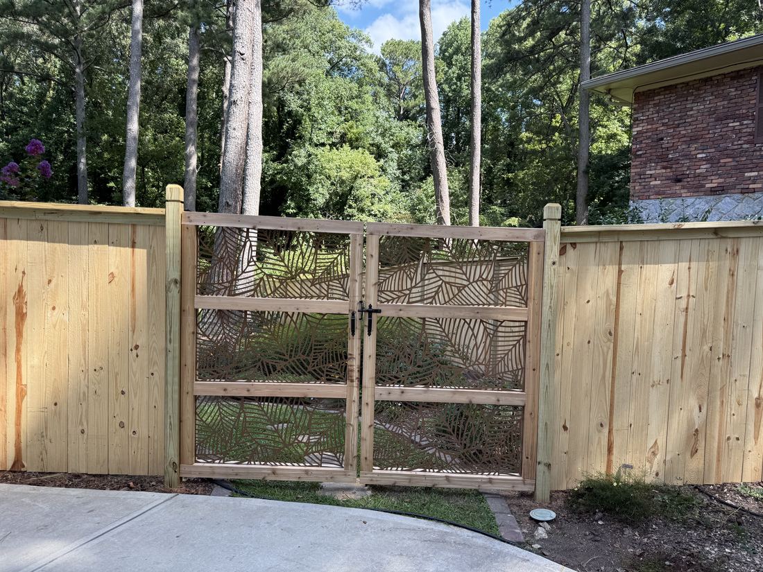 Custom wood double gate set into a cedar privacy fence