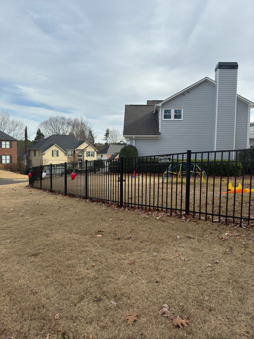 Black flat-top aluminum fence along a Peachtree Corners front lawn, installed by FenceWorks of Georgia