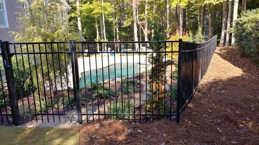 Ornamental aluminum flat-top pool fence installed by FenceWorks around a metro-Atlanta backyard pool