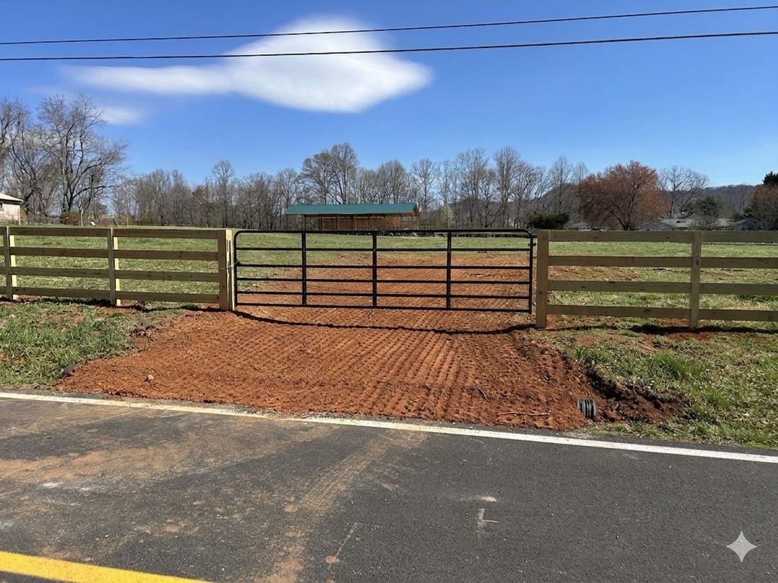Black steel tube farm and livestock gate on a horse-fence line