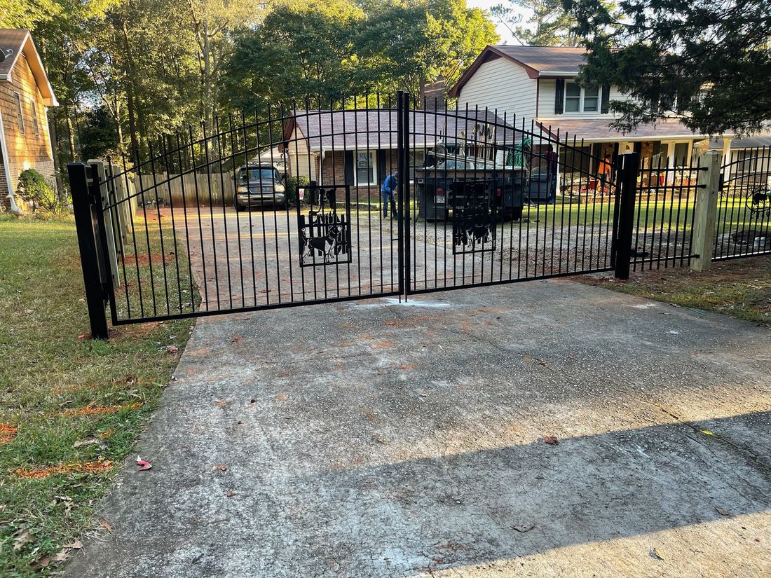 Welded-steel double drive gate with a custom cut logo