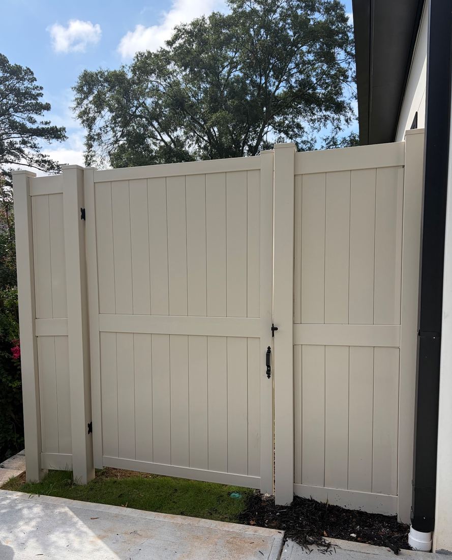 Tan vinyl privacy fence with a matching gate, 8 feet tall