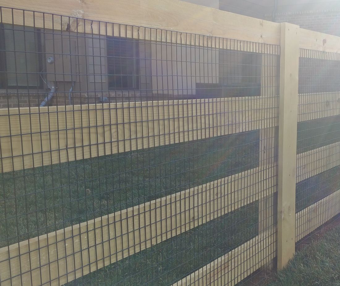 Wood four-rail ranch fence fitted with pool-compliant wire mesh