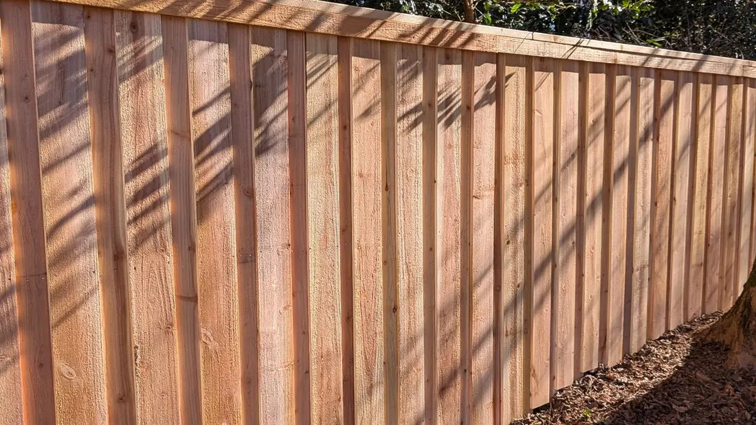 Cedar board-on-board capped privacy fence in afternoon sun, built by FenceWorks of Georgia