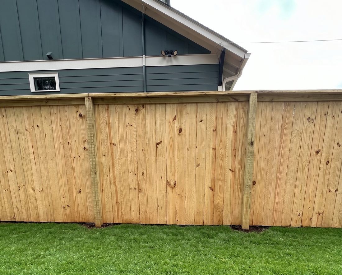 Capped flat-top wood privacy fence along a residential back yard, built by FenceWorks of Georgia