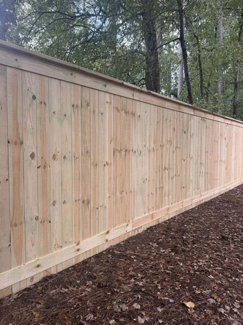 Capped wood privacy fence with hidden posts and a kickboard