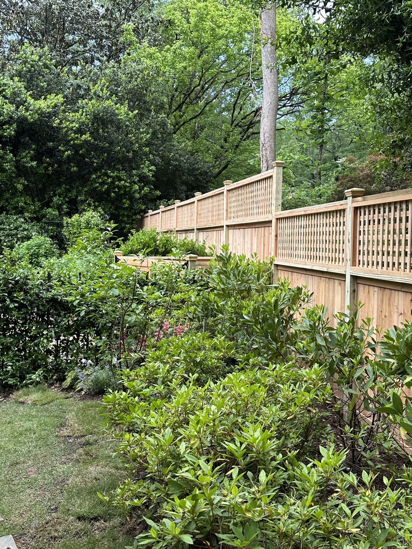 Capped wood privacy fence with a lattice top and post caps