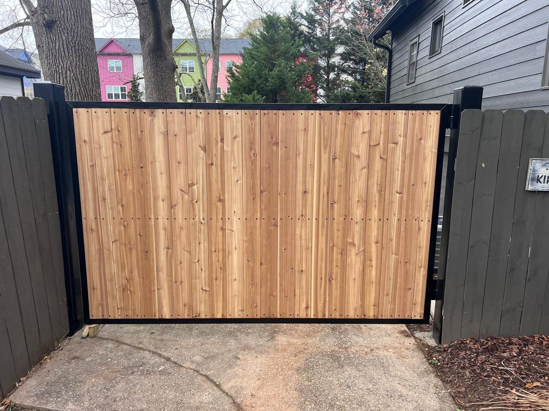 Custom cedar driveway gate on a welded steel box frame, built by FenceWorks of Georgia