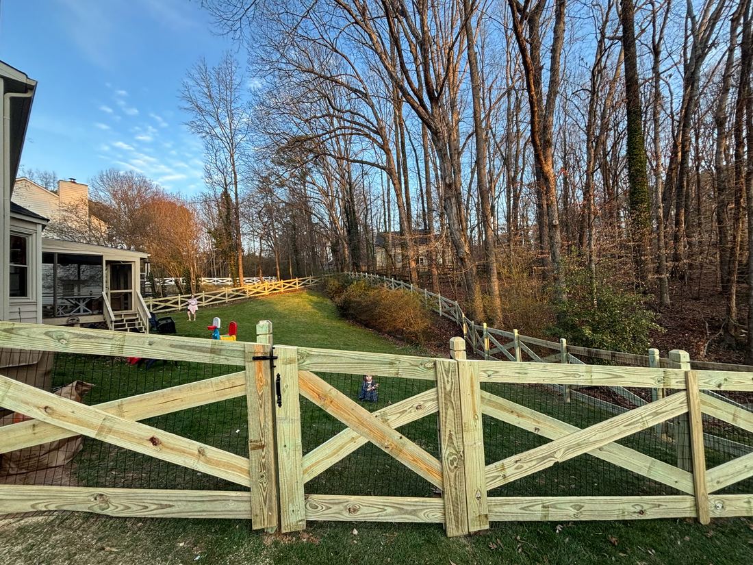 Wood crossbuck ranch fence with dado posts and black welded wire
