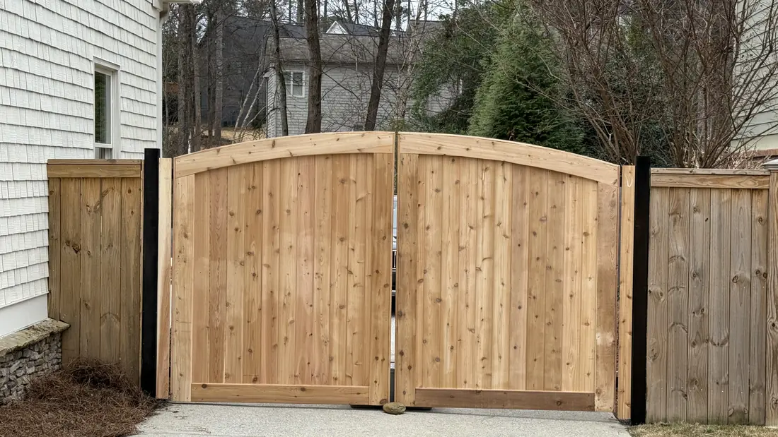 Custom arched cedar driveway gate and matching wood privacy fence at a Brookhaven, GA home, built by FenceWorks of Georgia