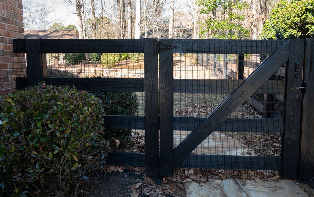 Wood four-rail ranch fence with welded wire and a matching gate