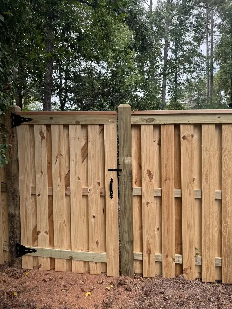 Shadowbox capped wood privacy fence with a matching walk gate in a residential yard