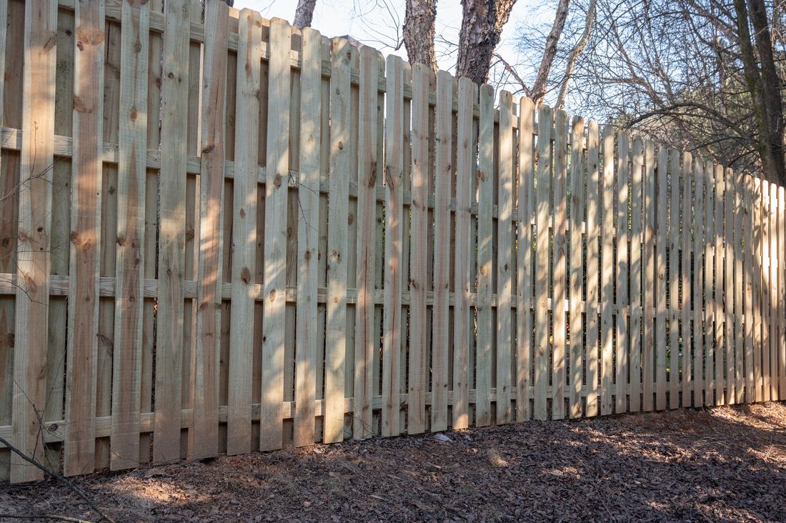 Capped wood shadowbox privacy fence along a residential yard, installed by FenceWorks of Georgia