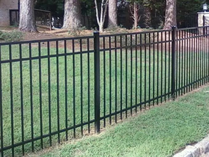 Flat-top black aluminum fence running along a front lawn
