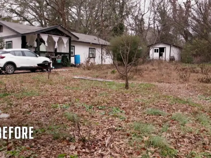 The Atlanta backyard before the HGTV renovation: bare ground, leaves, and no fence line