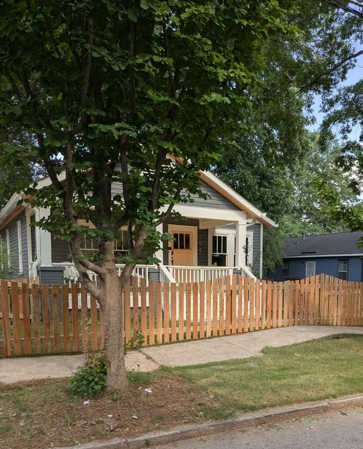 Scalloped cedar picket fence around the front yard of an Atlanta bungalow